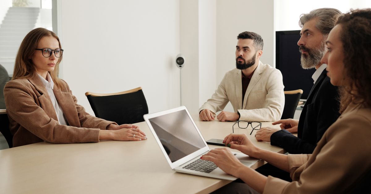 Business meeting with diverse team in modern office setting, focused on planning and cooperation.